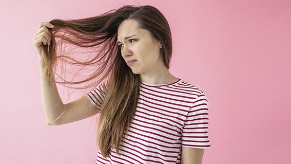 femme inquiète observant ses cheveux